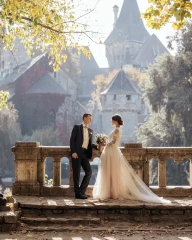 A guy with a girl in the sunshine near a stone balcony